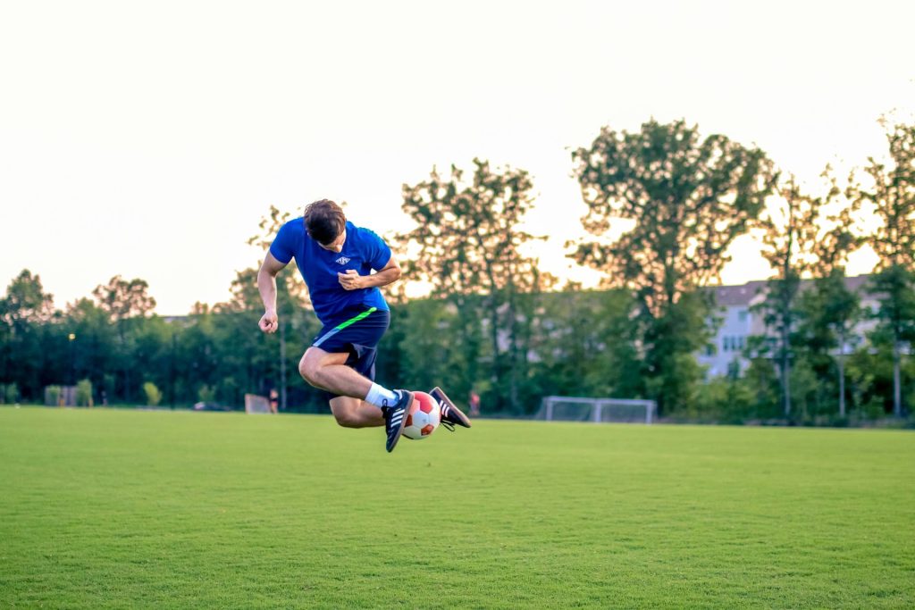 Spieler springt über den Ball
